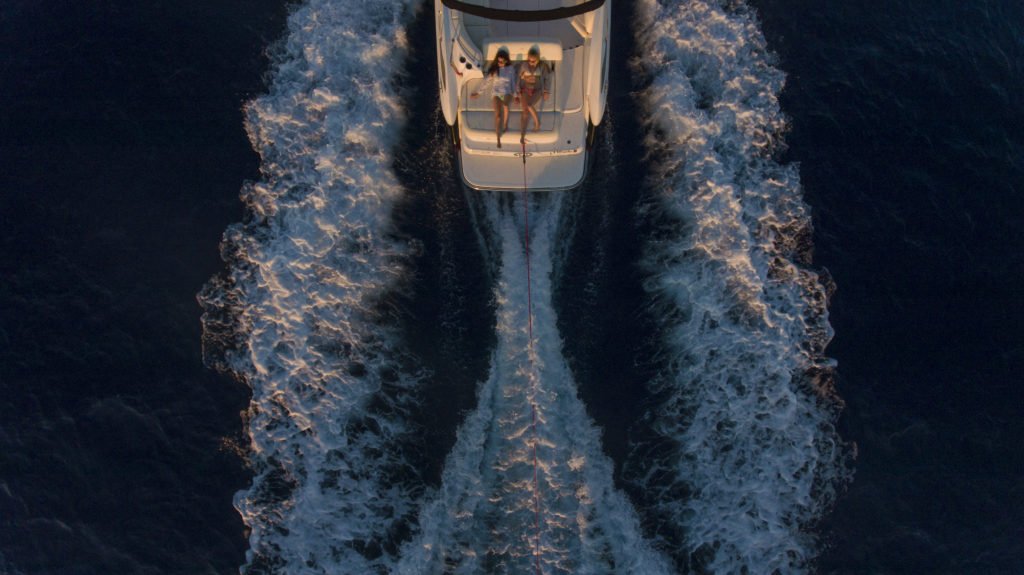 2 girls laying on back of a moving boat in Mallorca